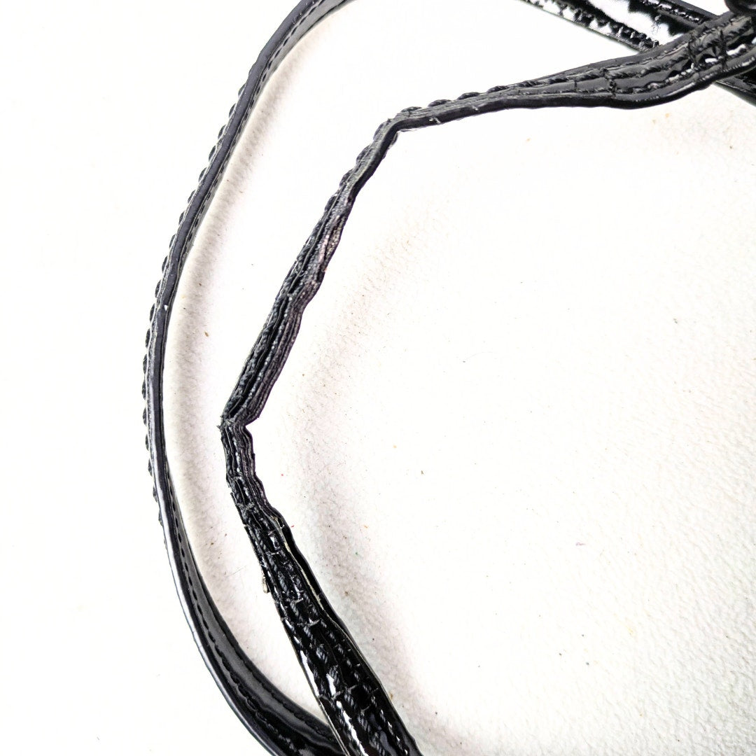 The close-up view of the worn down handles of the COACH Poppy Mini Oxford Convertible Satchel Handbag, photographed on the white background.