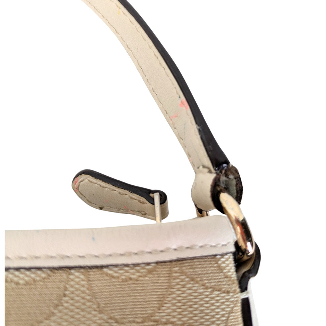 The view of the stain located att he crossbody strap of the COACH Signature Jacquard Crossbody Bag.