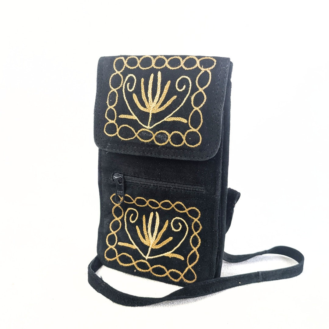 Handmade convertible soft suede embroidered bag photographed form the left side.