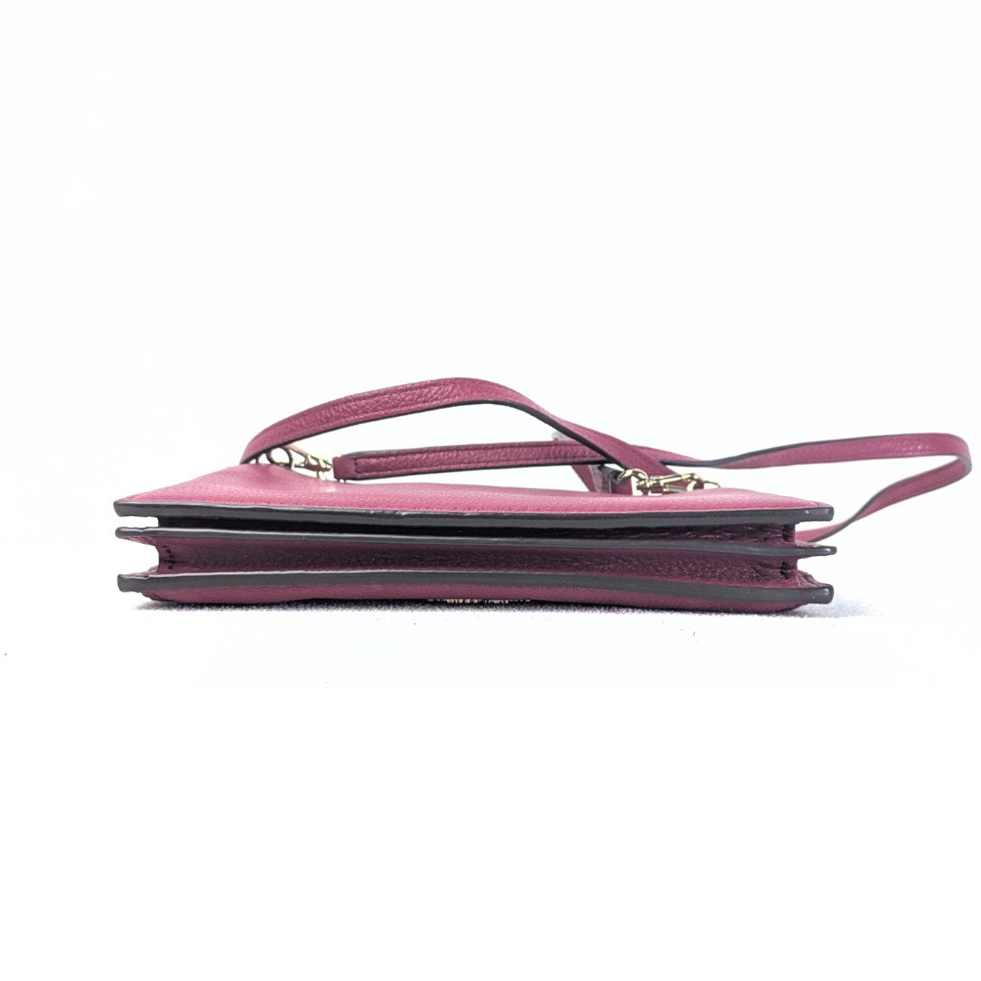 The bottom view of the Kate Spade Larchmont Avenue Alegra Crossbody Bag in Burgundy captured on the white bavkground