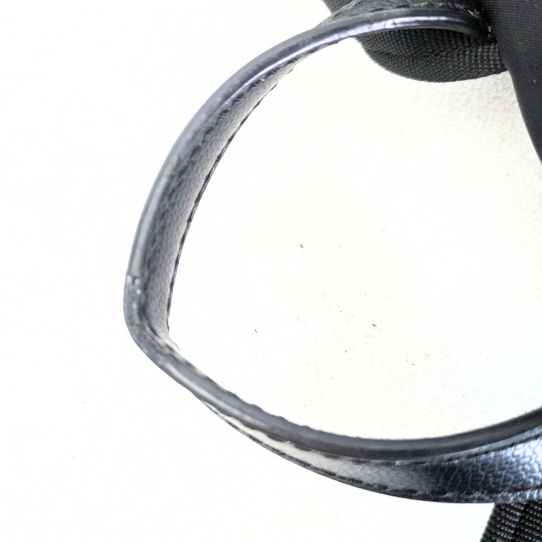 The close-up of the Kate Spade Medium Nylon Backpack's top handle on the white background.