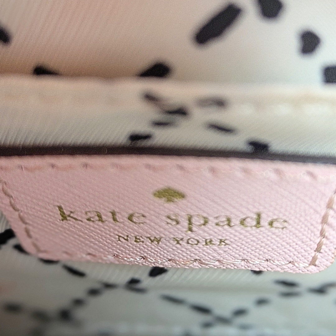 The view of the leather embossed logo patch inside the Kate Spade New York Newbury Lane Sally Crossbody Bag.