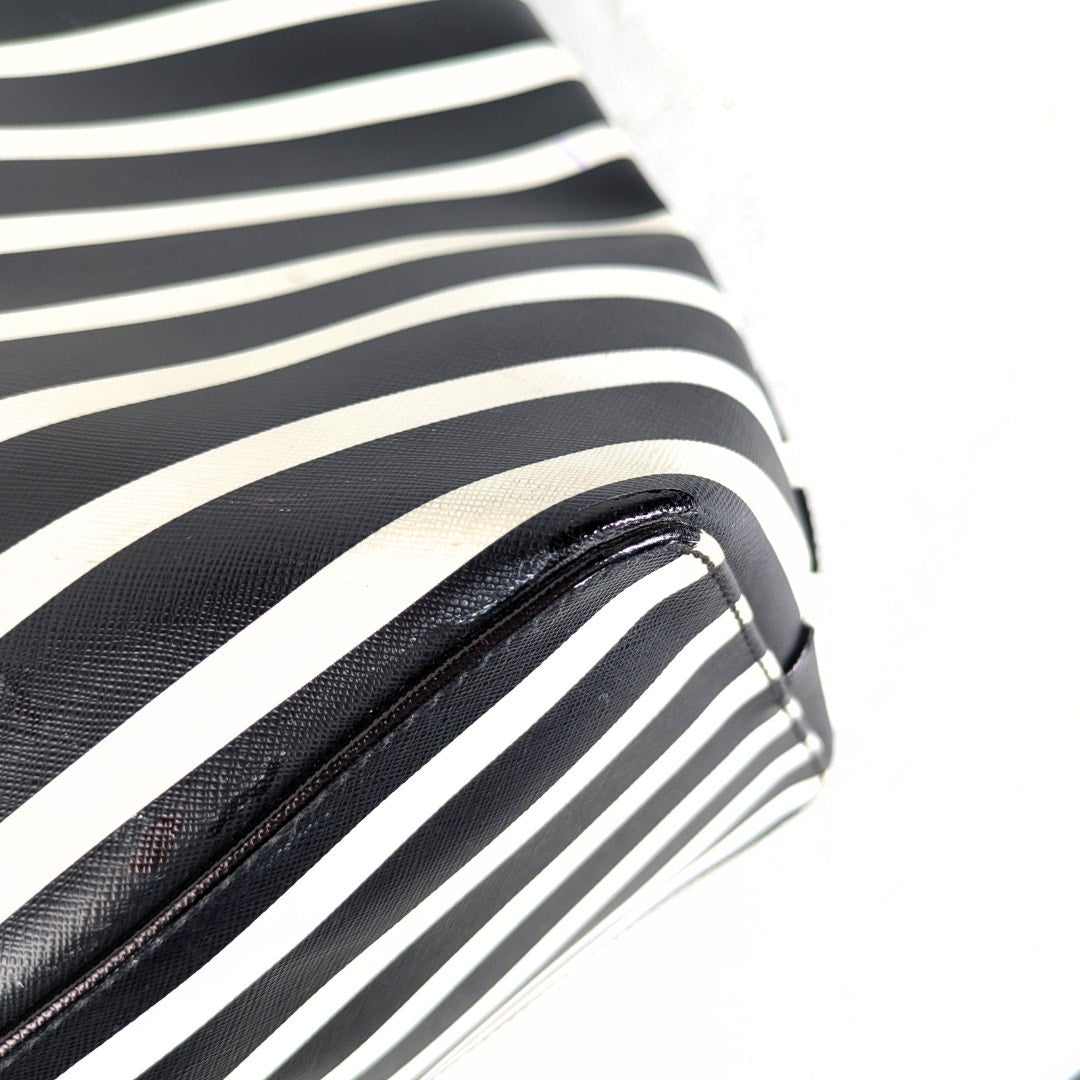 The bottom corner of the Kate Spade Shore Street Sailing Stripe Margareta Tote Shoulder Bag.