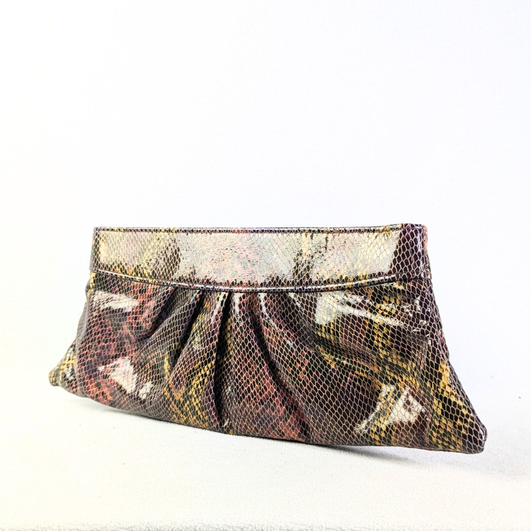 A multicolor python skin pattern faux leather clutch with a gold-tone canvas lining, and a placard embossed logo.