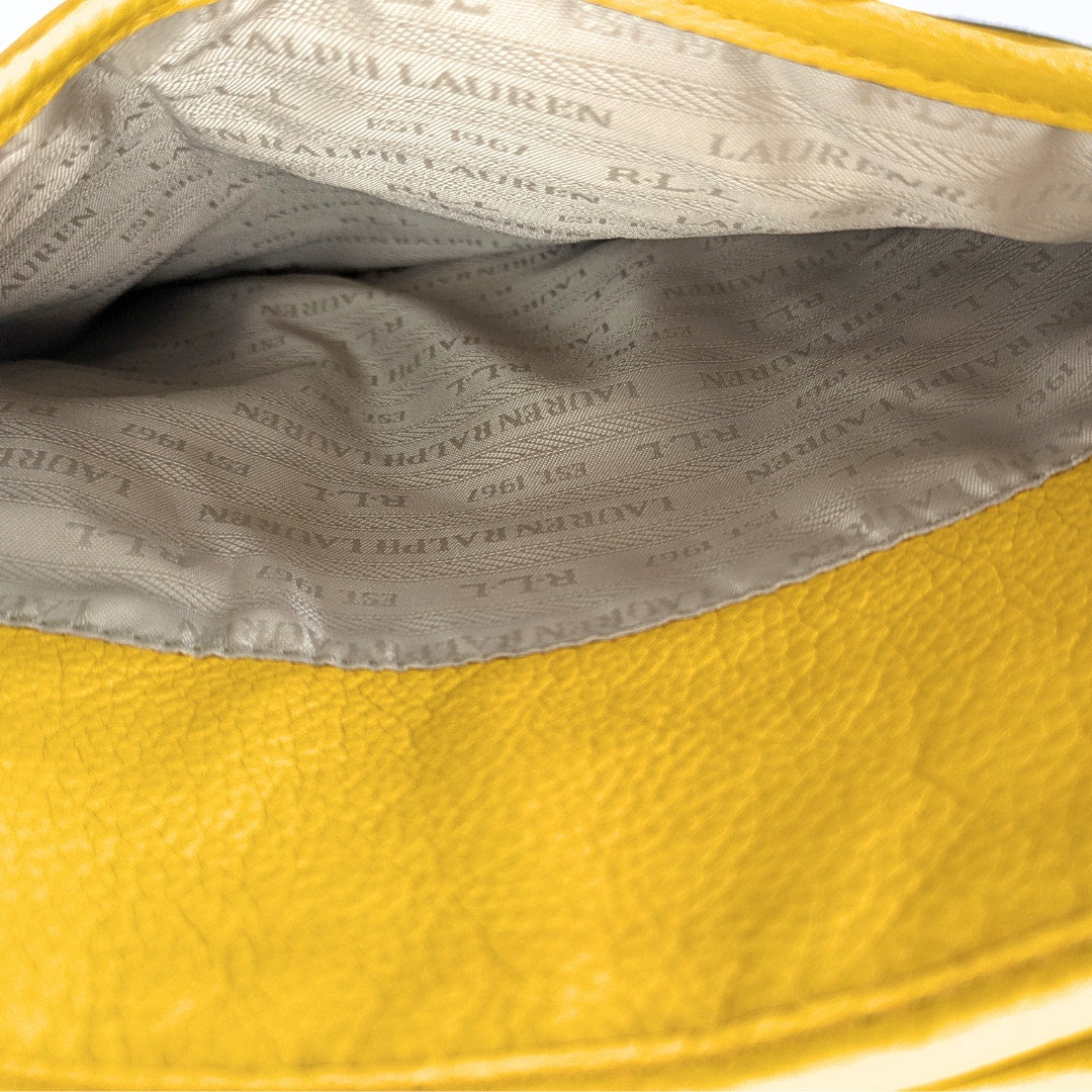 Close-up of yellow leather handbag interior with logo pattern.