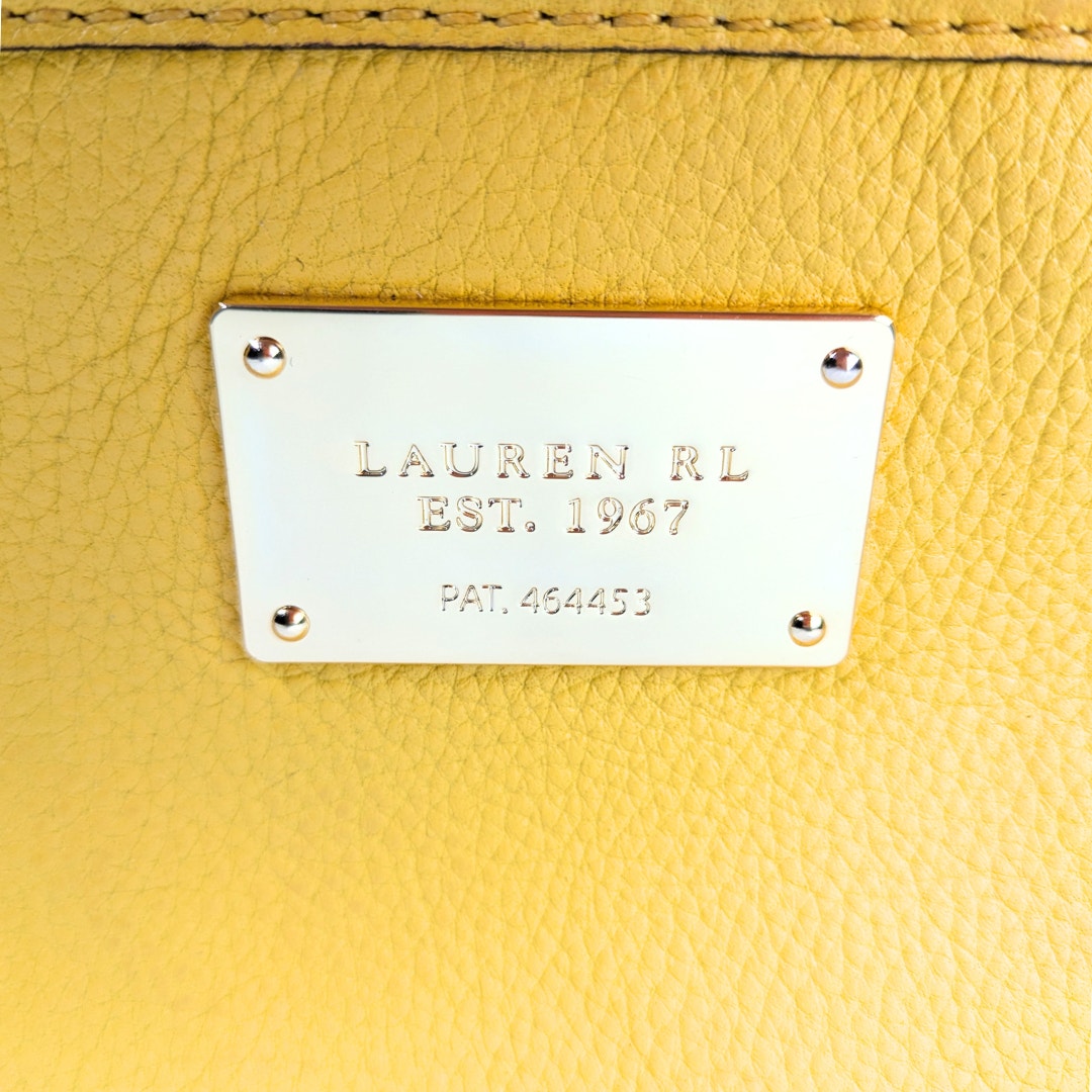 Close-up of a yellow leather product with a gold label.