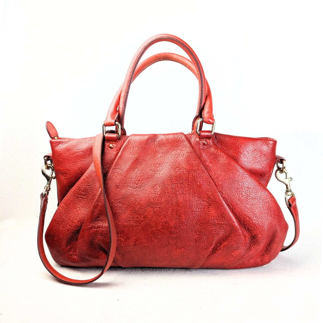 The back view of the MCM Monogram Embossed Leather Satchel Shoulder Bag.