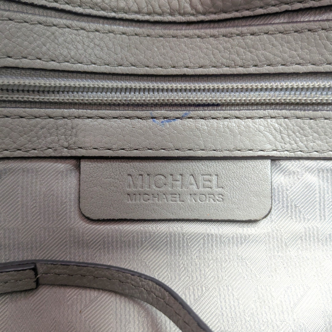 The close-up on the leather embossed logo patch inside the Michael Kors Bedford 2-way Convertible Crossbody Bag.