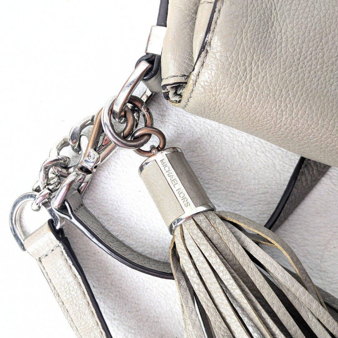The close-up on the scratched hardware of the Michael Kors Bedford 2-way Convertible Crossbody Bag.