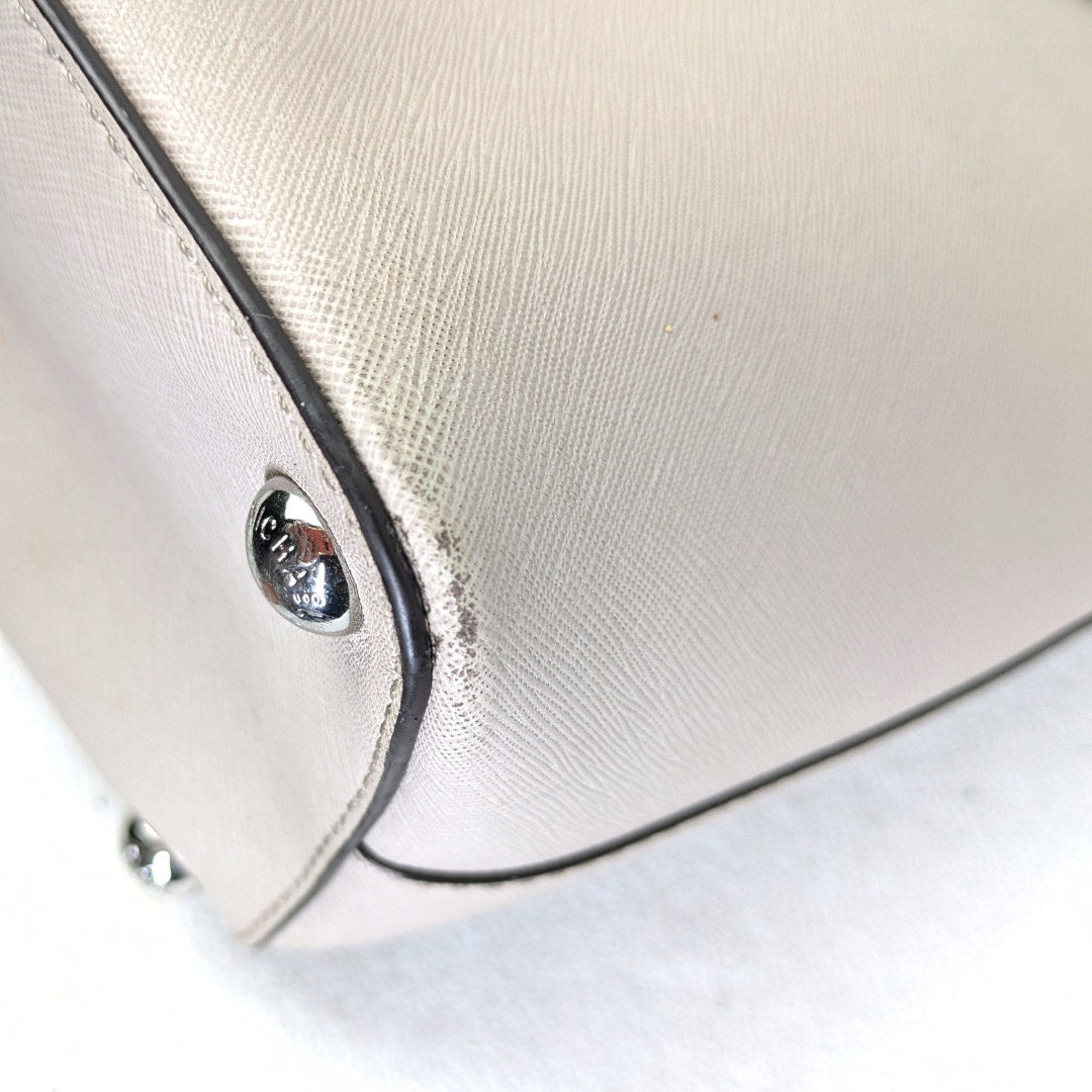 The view of the left bottom corner of the pre-loved Michael Kors Jet Set Medium Saffiano Leather Tote.
