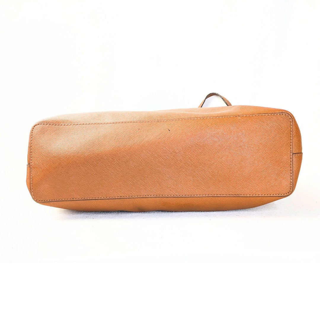 The bottom view of the Michael Kors Jet Set Medium Tote Bag in camel on the white background.