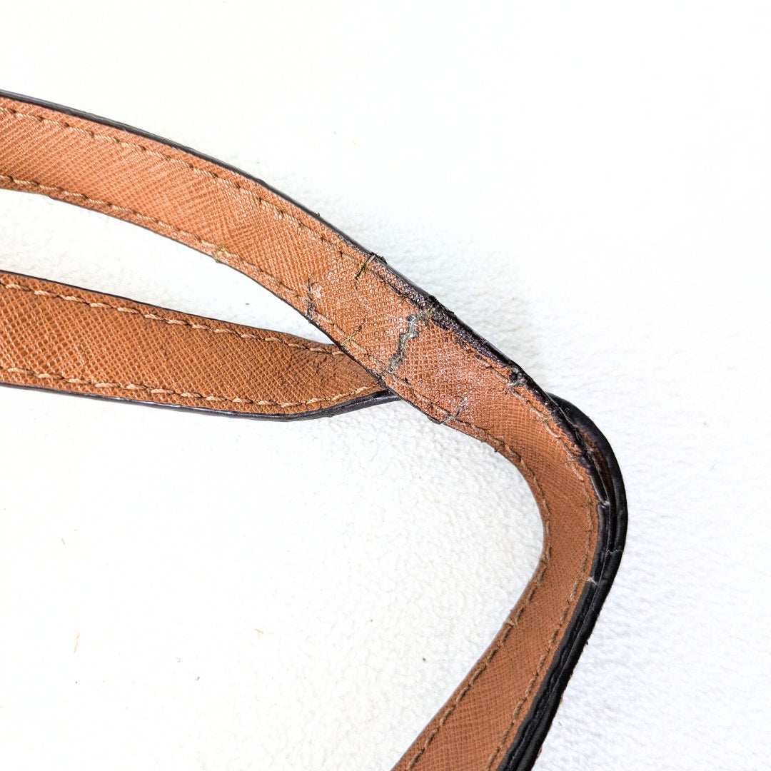 The close-up view of the cracked leather on one of two shoulder handles.