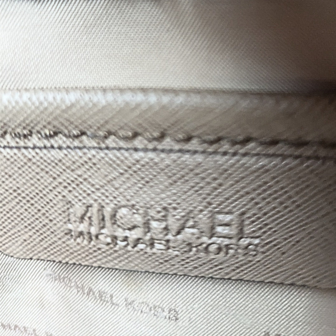 The close-up on the leather embossed leather patch of the Michael Kors Quinn Large Saffiano Leather Satchel.