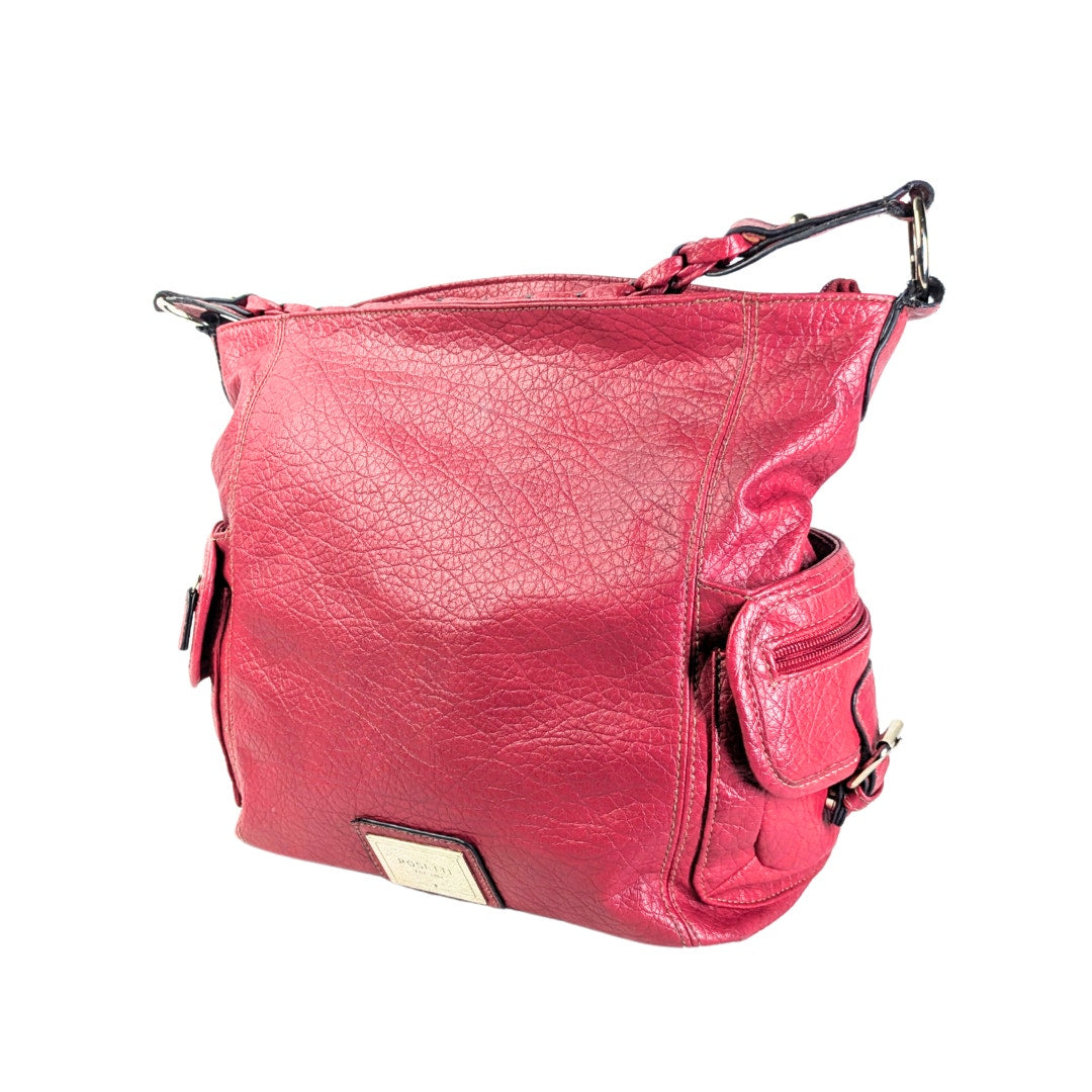 A pre-loved Rosetti faux-leather hobo shoulder bag in burgundy with black trimming and silver hardware, featuring two side pockets and a braided shoulder strap.