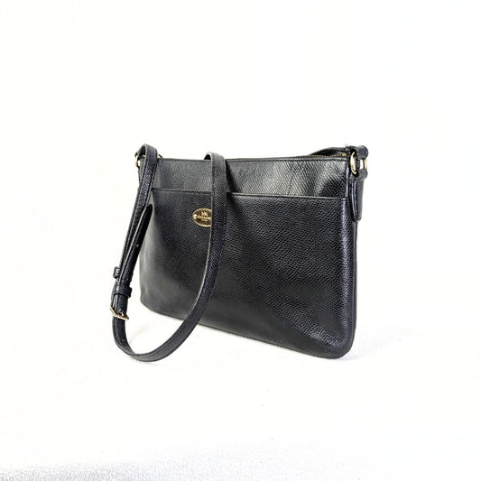 A black Coach Polly Crossgrain Leather Crossbody Bag with gold-tone hardware, an adjustable leather strap, and a front slide pocket.