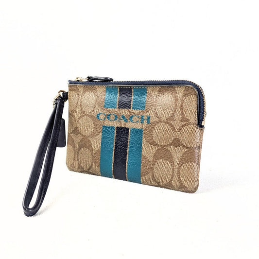 A pre-owned COACH signature canvas stripe wallet pouch with a beige, navy blue, and turquoise color scheme, featuring a leather wristlet handle.
