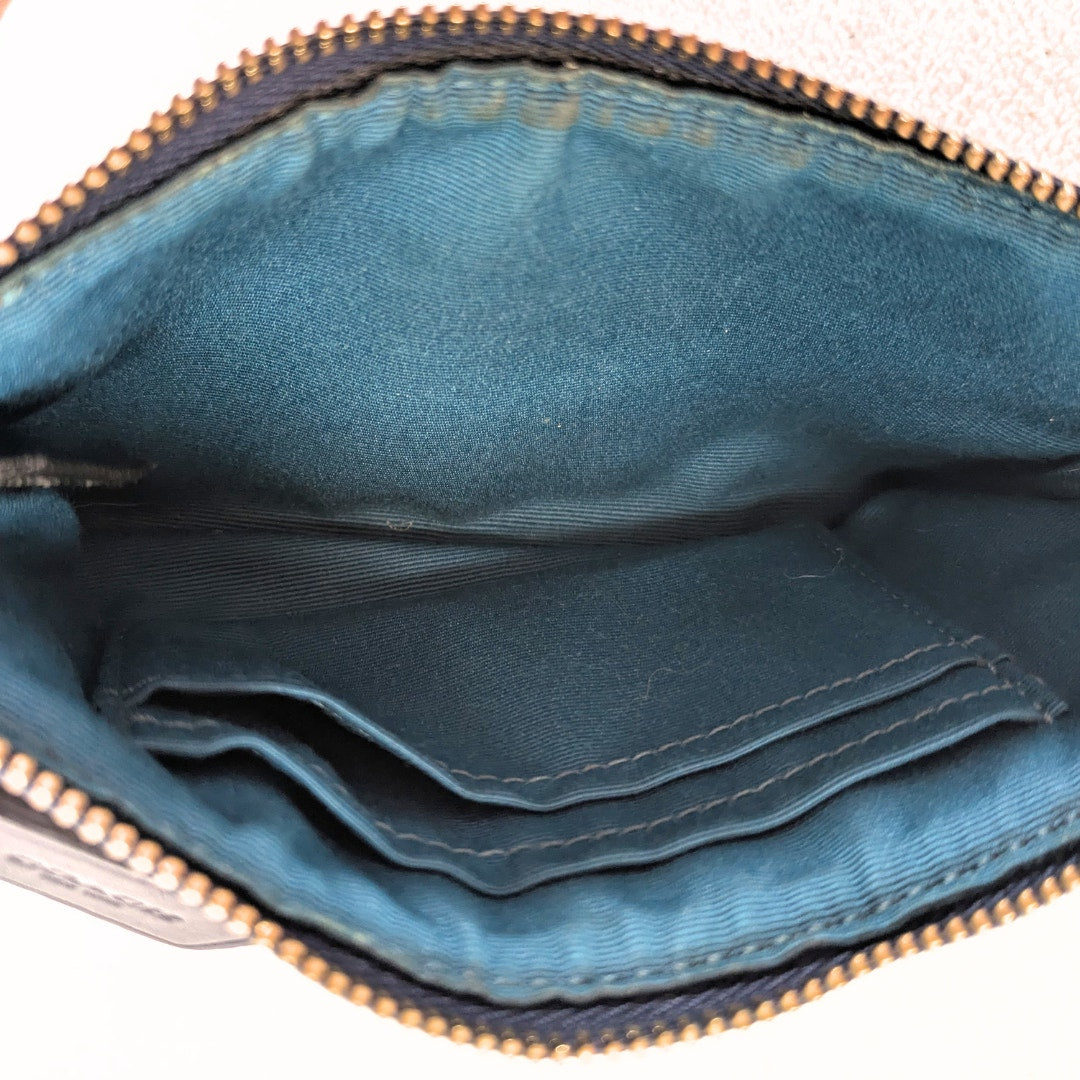 The inside view of the COACH Signature Canvas Stripe Wallet Pouch photographe dont he white background. 