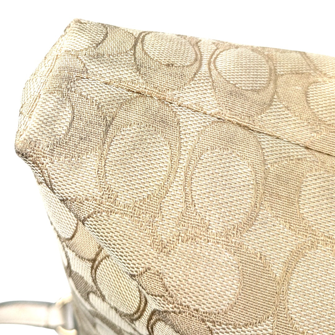 The bottom corner of the COACH Signature Jacquard Crossbody Bag.