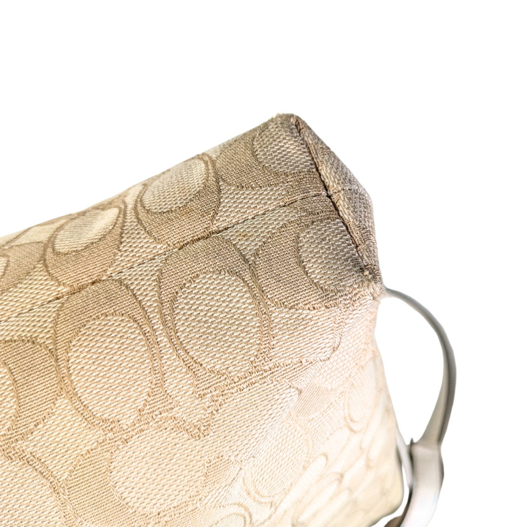 The bottom corner of the COACH Signature Jacquard Crossbody Bag.