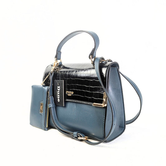 A navy blue Dune London satchel handbag with a convertible crossbody strap, featuring a black patent leather flap, gold-tone hardware, and a matching wallet.