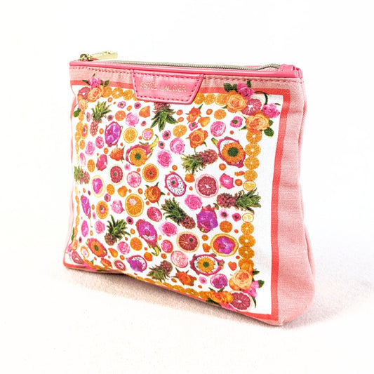 A pink Estée Lauder makeup bag with a small citrus fruits print and gold hardware on a white background. 