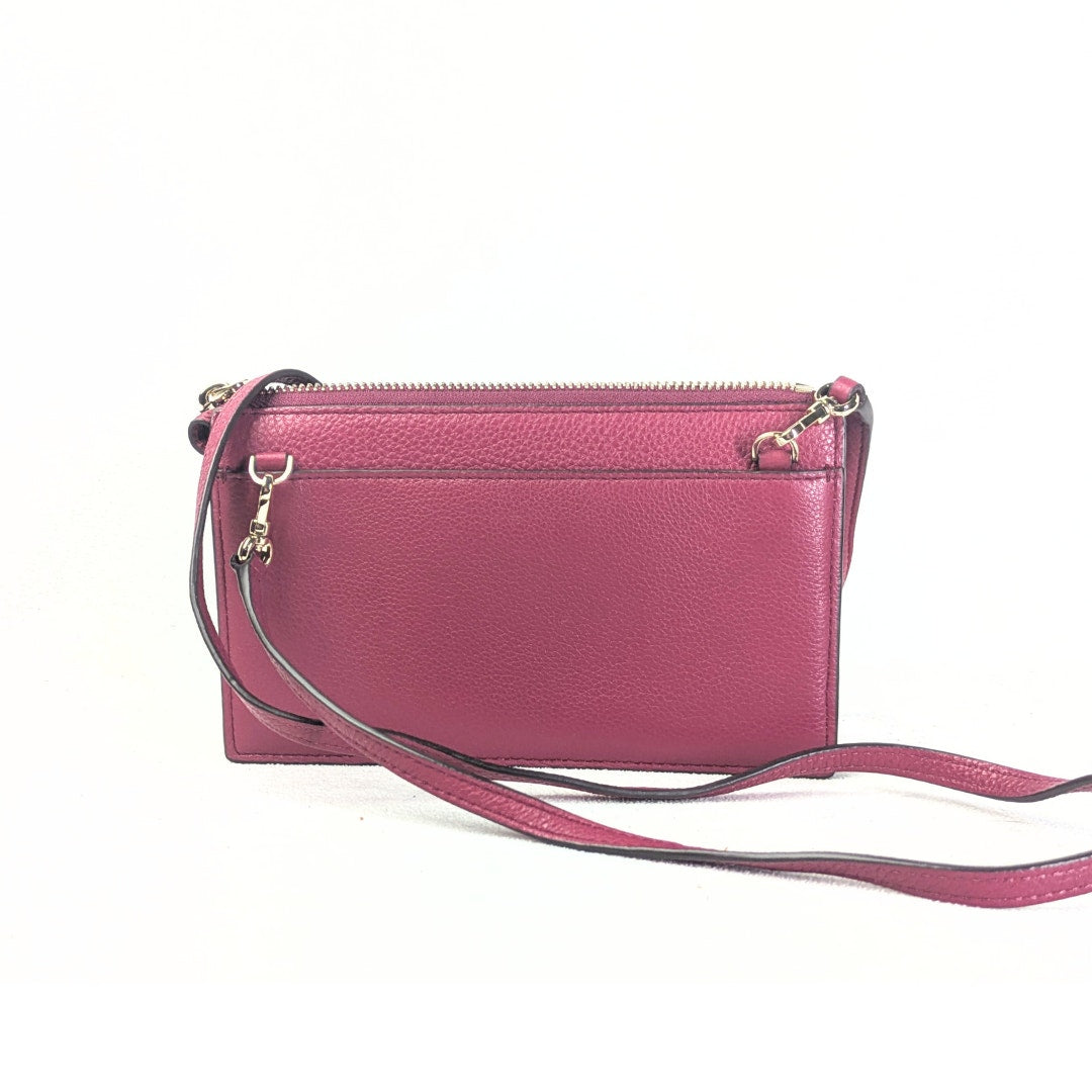 The back side of the Kate Spade Larchmont Avenue Alegra Crossbody Bag in burgundy photographed on the white background. 