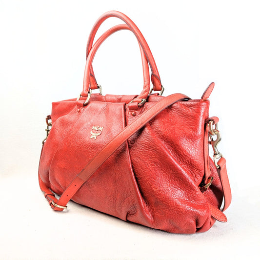The view of the MCM Monogram Embossed Leather Satchel Shoulder Bag from the left angle. 