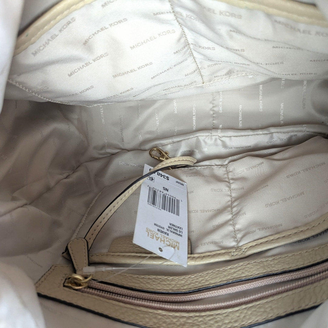 The close up on the back side of the tag inside Michael Kors Raven Large Leather Shoulder Bag.