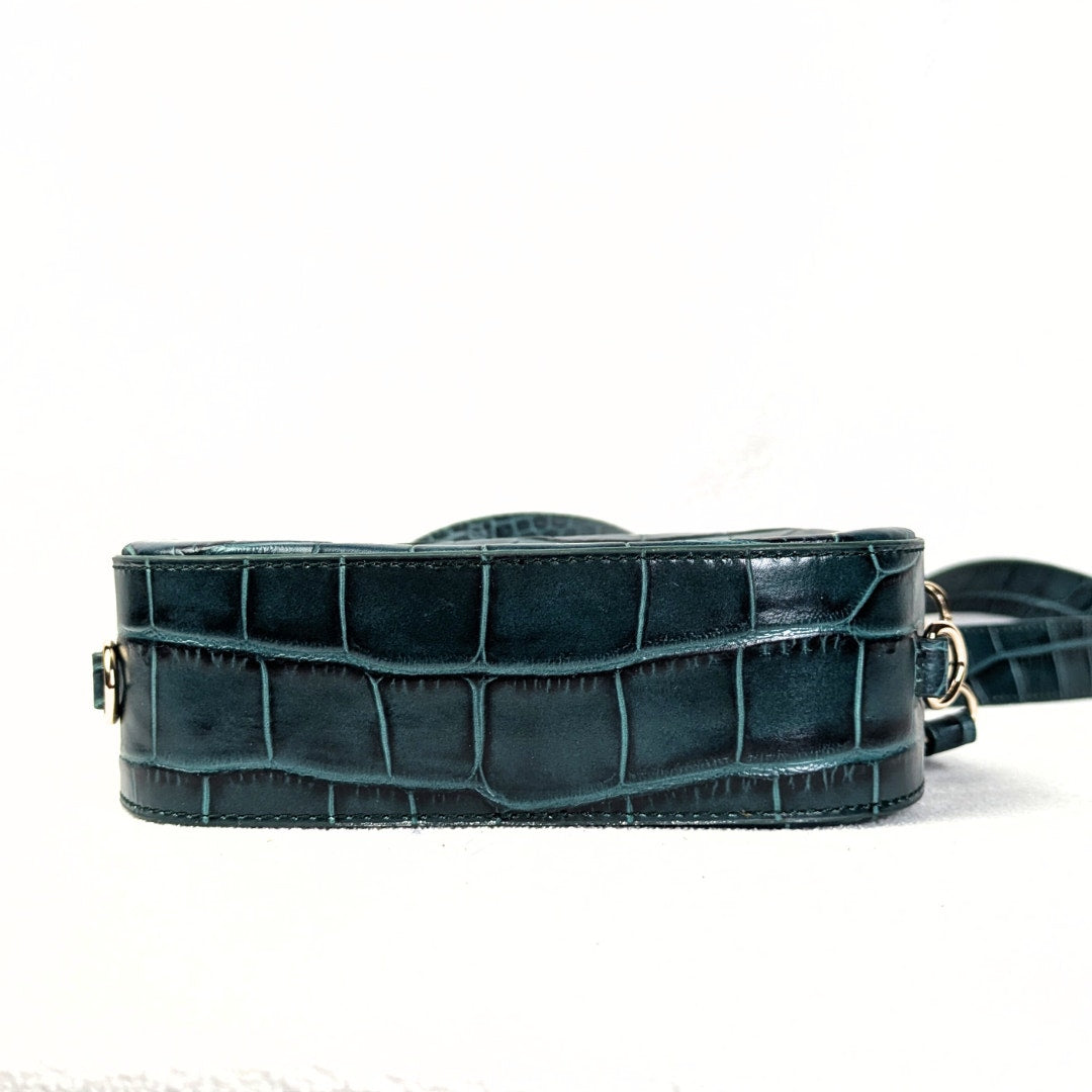 The view of the bottom of the Pop & Suki Crocodile Embossed Leather Camera Crossbody Bag, captured on the white background. 