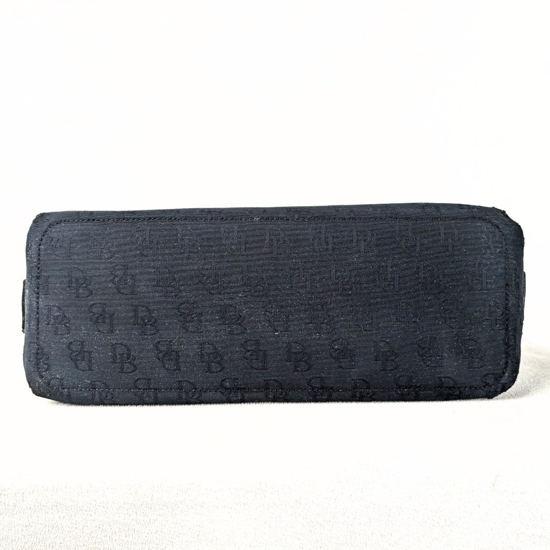 Pre-loved Dooney & Bourke Monogram Canvas Satchel with Tassel in Black photographed from the bottom. 