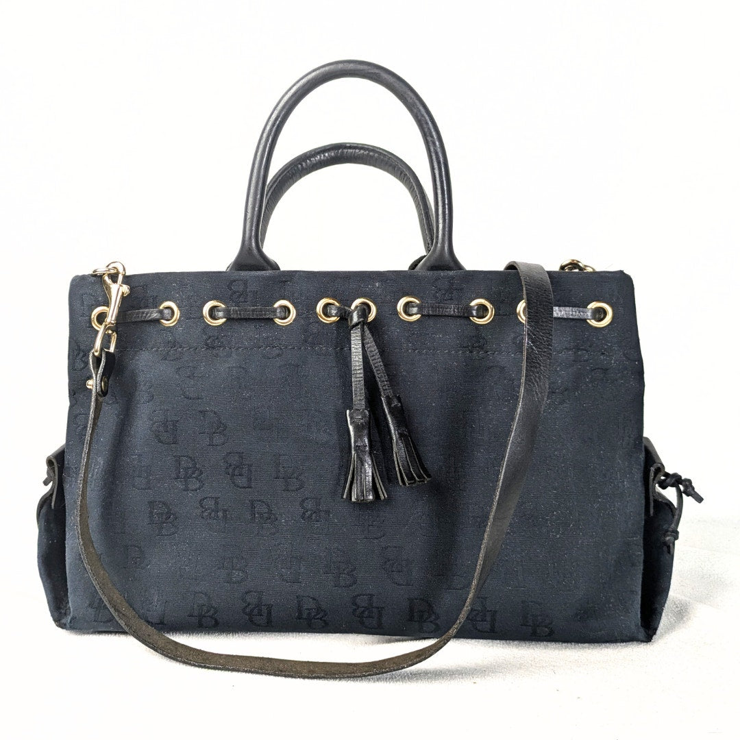 Pre-loved Dooney & Bourke Monogram Canvas Satchel with Tassel in Black photographed from the front side. 