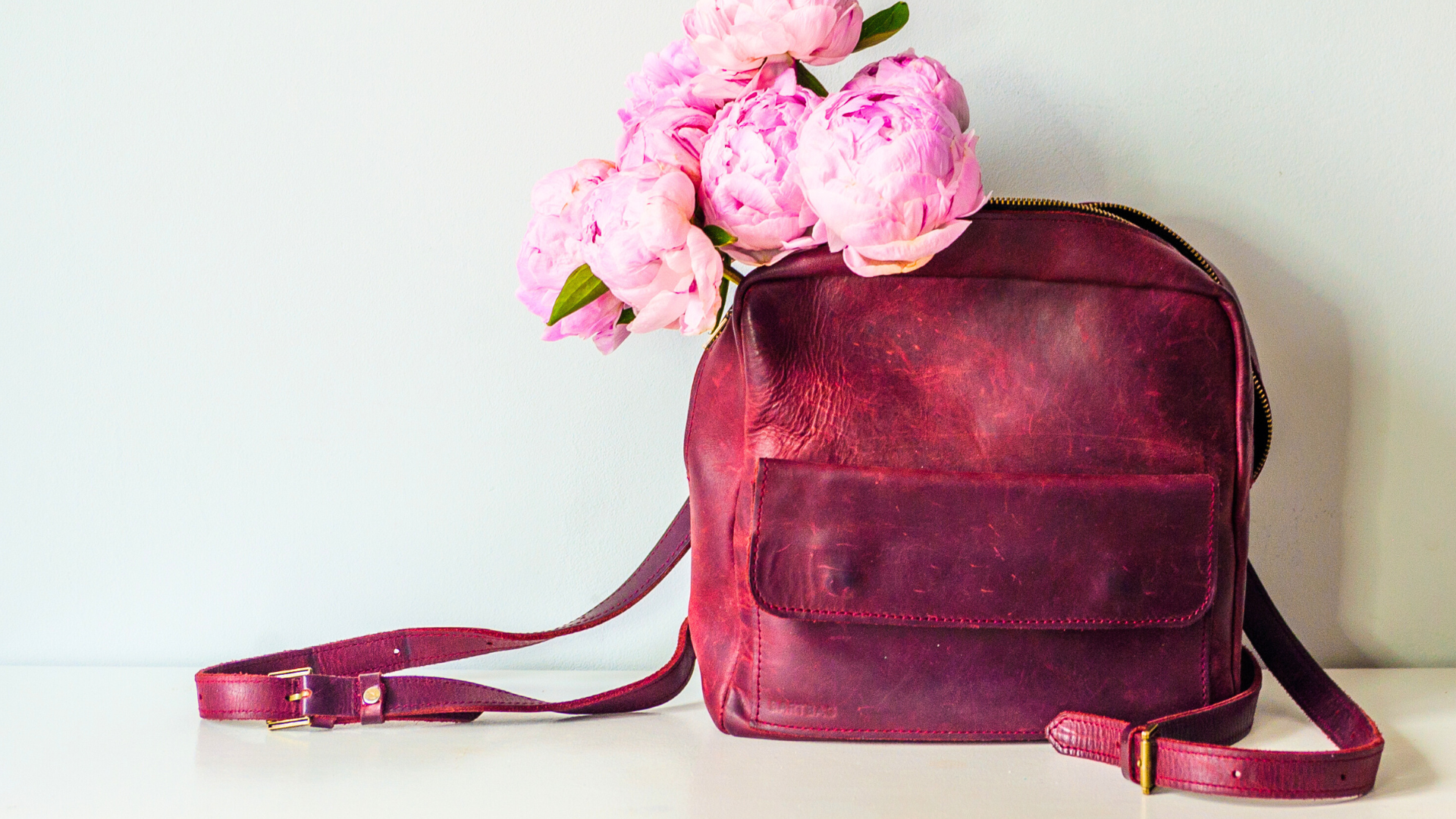 Magenta leather backpack with pink flowers on a white background