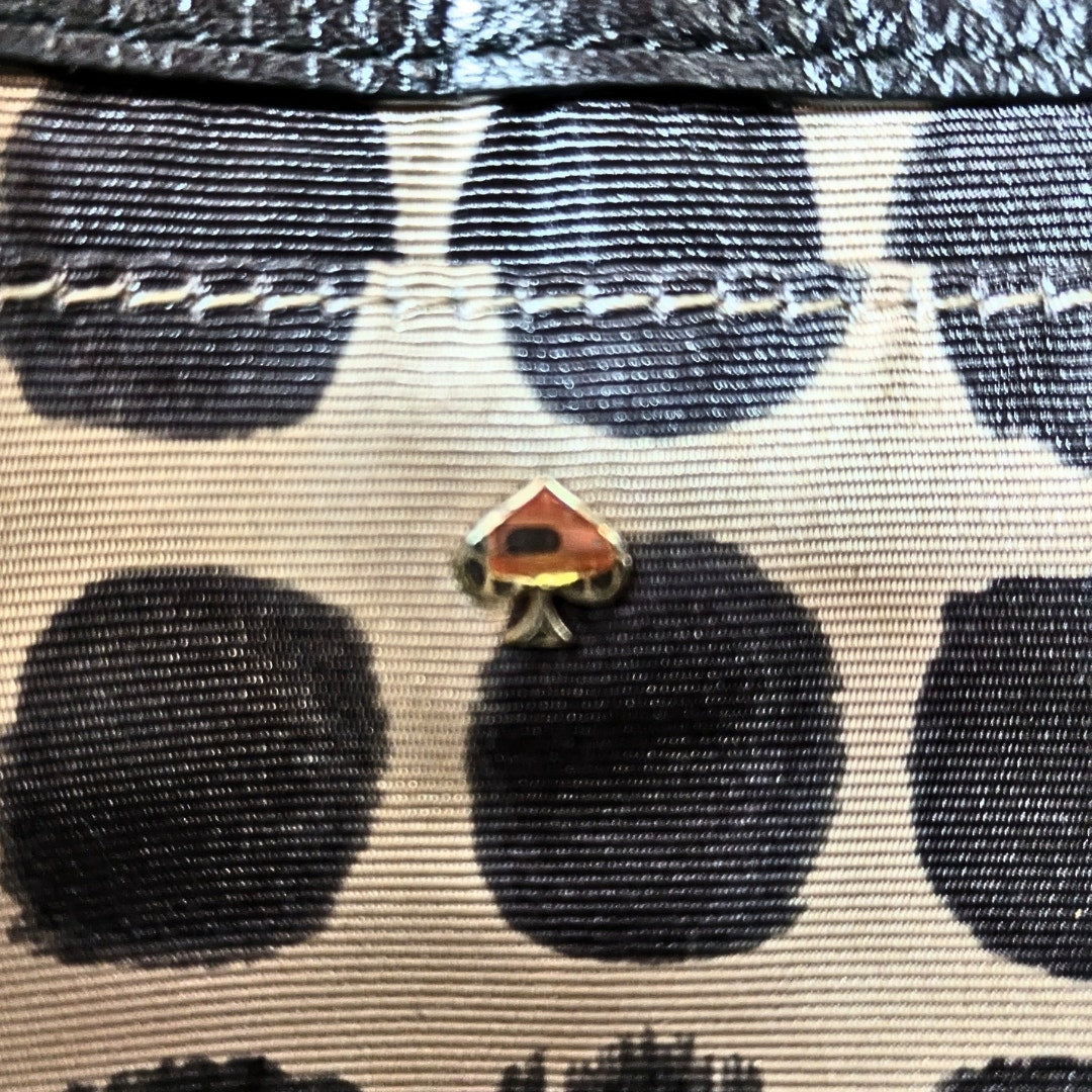 Metal Logo Plaque of the Kate Spade Sadie Envelope Mini Crossbody Bag.
