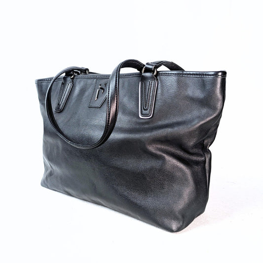 A black vegan leather tote shoulder bag with two shoulder straps and a top zip, featuring silver-tone hardware.